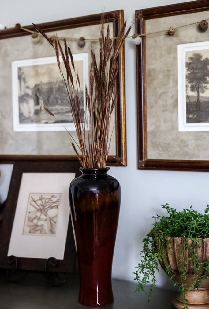 tall vase with dried wheat in it