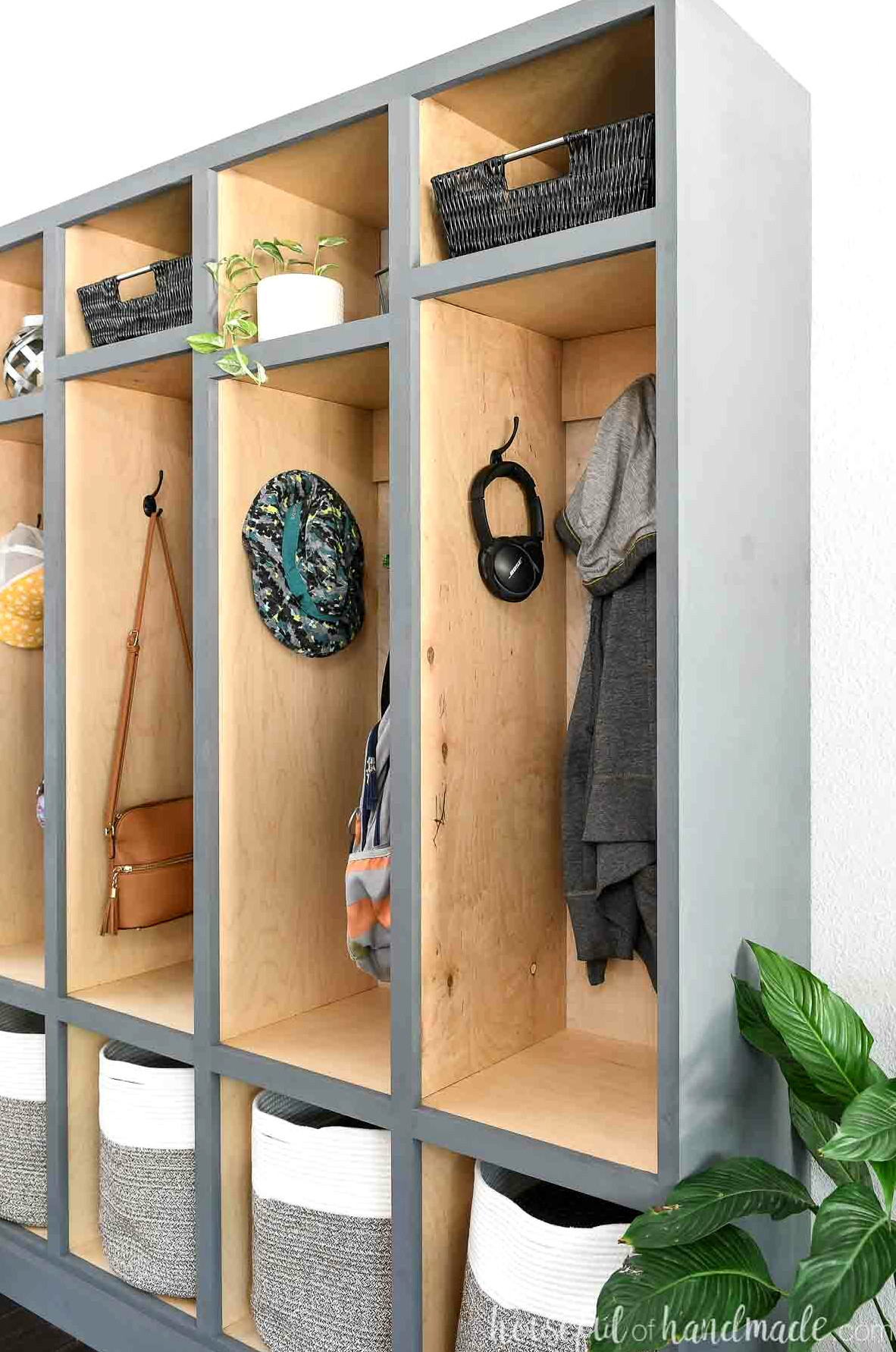 Side perspective of the mudroom lockers with birch wood interiors and painted gray exteriors. 
