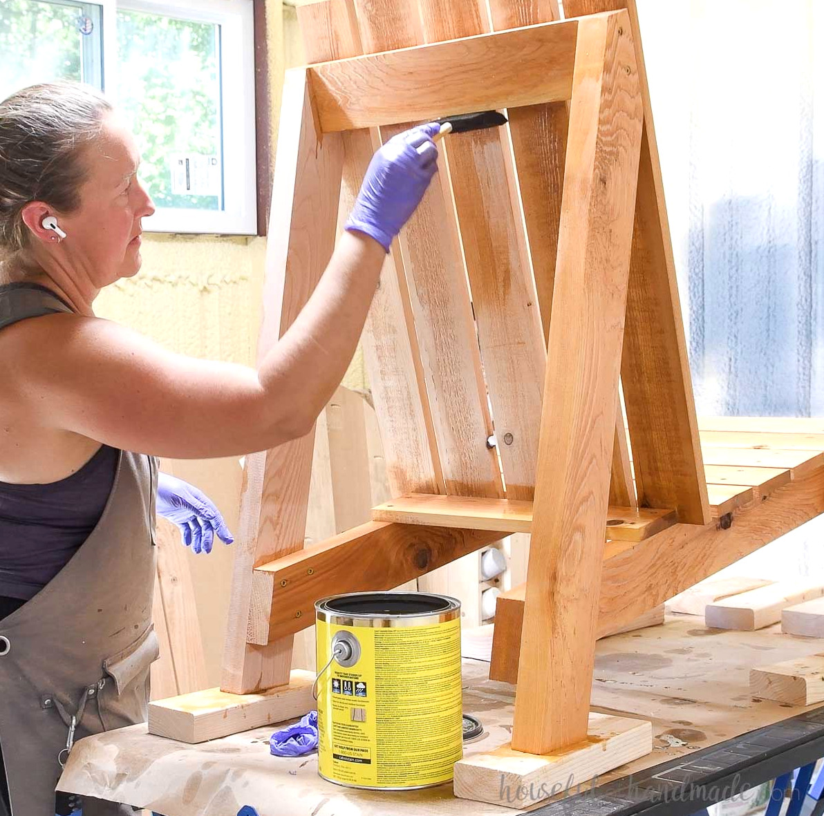 Applying outdoor sealer to the cedar adirondack chair.
