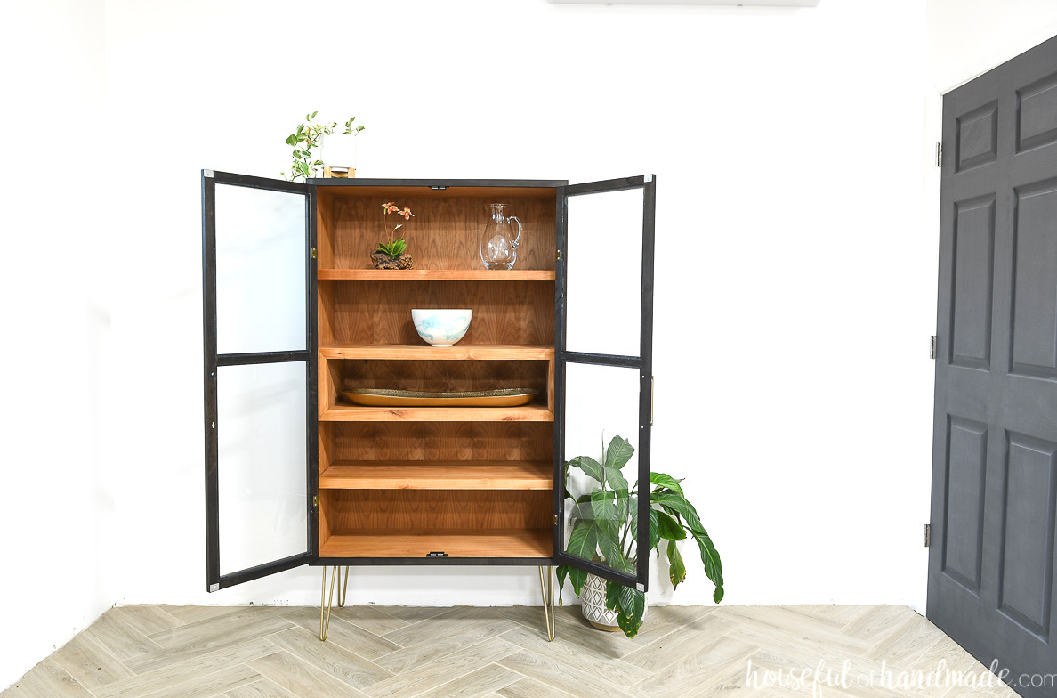 DIY display cabinet with open glass doors revealing the stained wood interior.