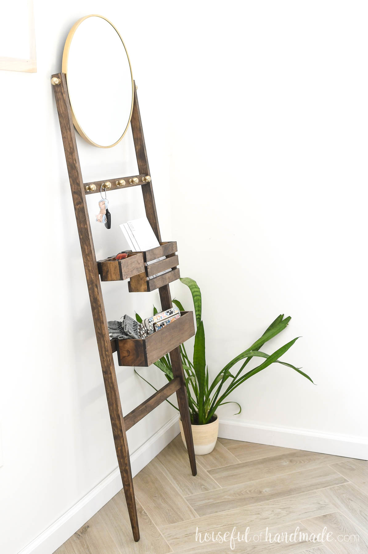 Walnut-finished entryway ladder with storage bins, hooks, and a mirror.