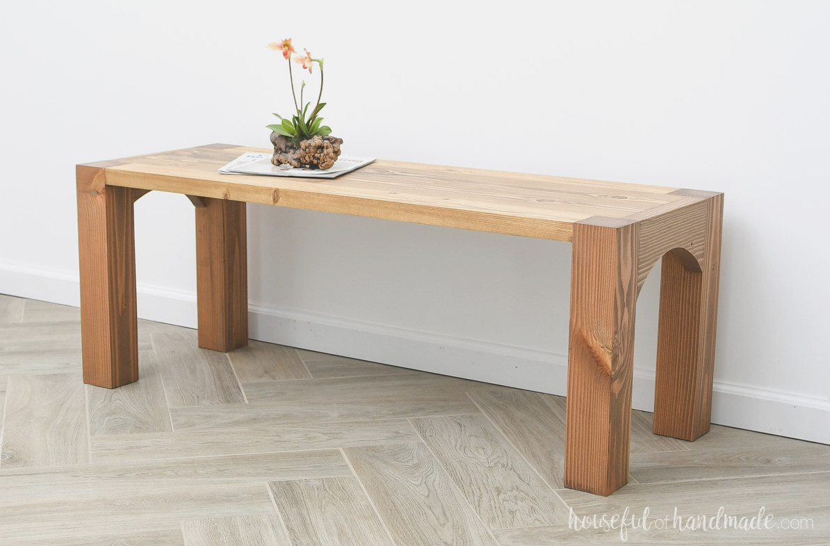 Solid wood coffee table with one shelf and arches between the side legs. 