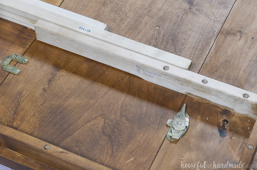 Table leaf lock unattached and the leaf slide in between the table top and breadboard end.