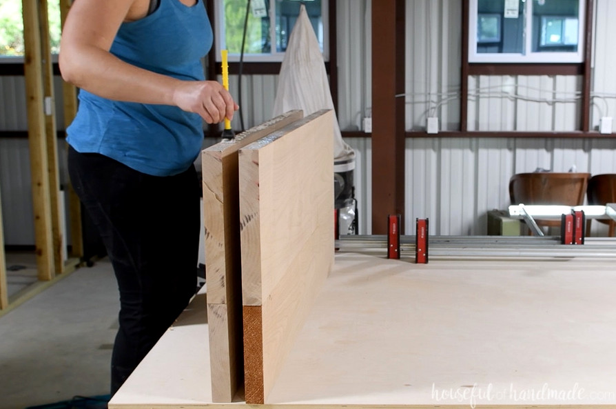 Spreading wood glue along the joining edge of the two assembled tabletop sections.