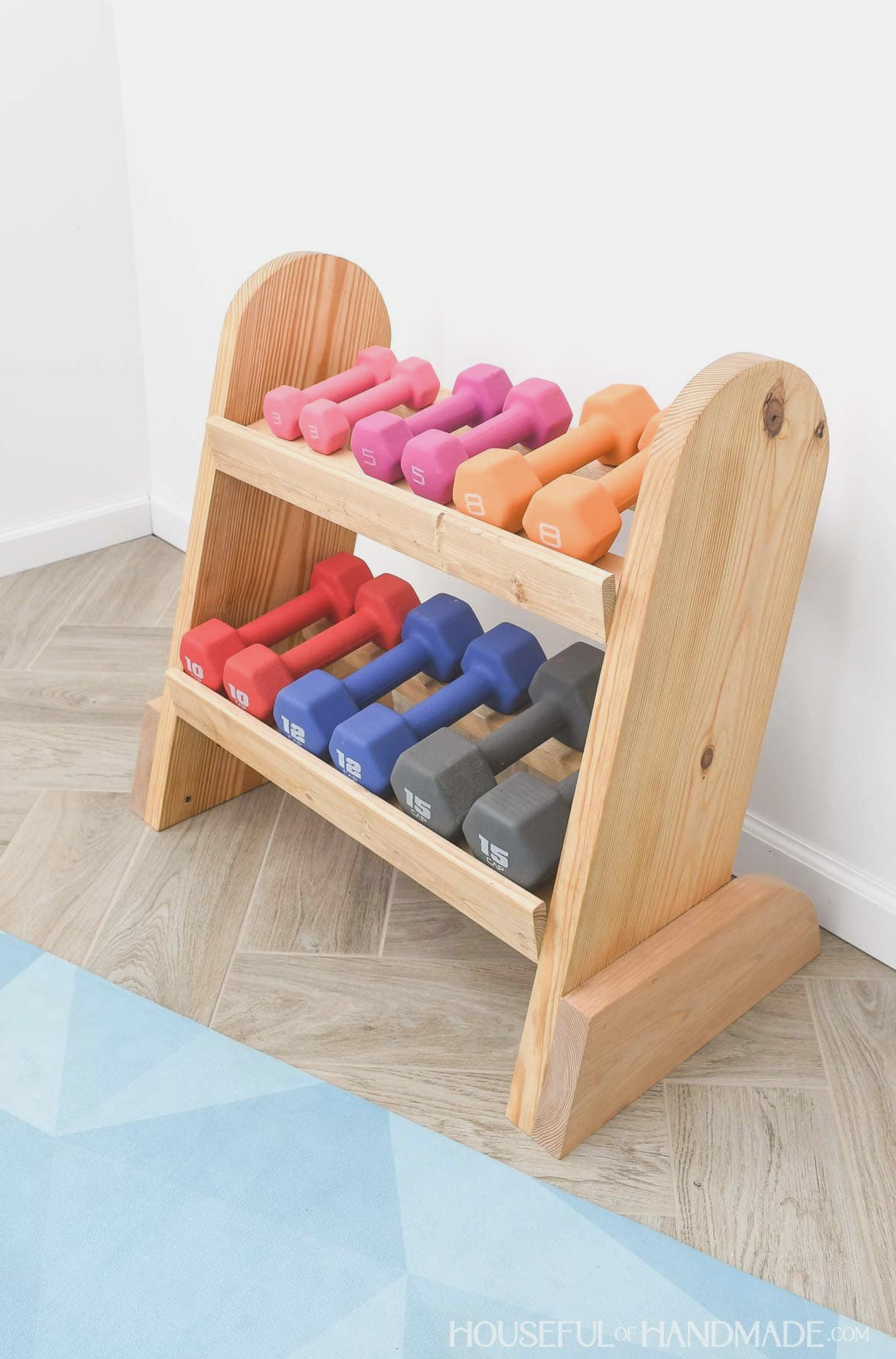 Wooden weight rack holding 6 pairs of dumbbells.