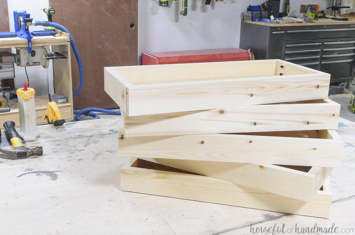Five planter box frames assembled and resting on a workbench.