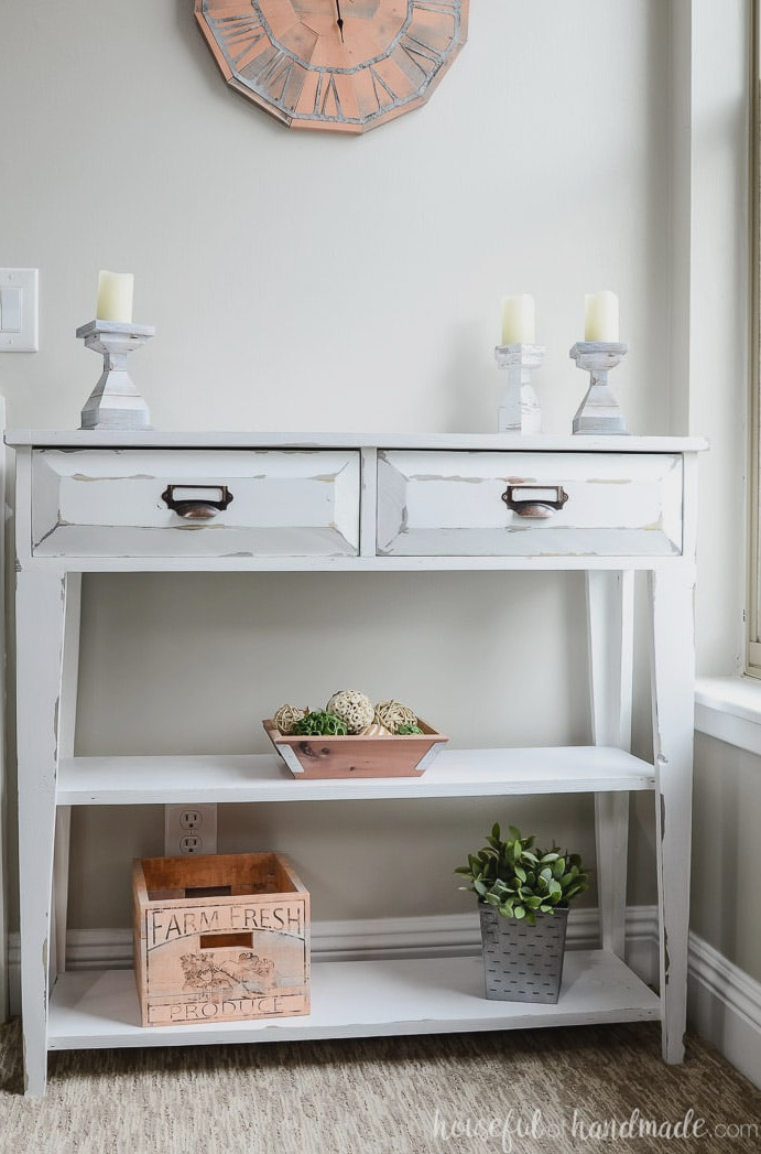 Create a lovely small console table for added storage and home decor. This DIY farmhouse console table features two spacious drawers and two shelves. An ideal storage solution for compact spaces. Housefulofhandmade.com Compact farmhouse console table with two drawers and open shelves. Housefulofhandmade.com
