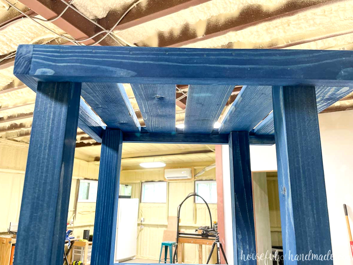 Attaching the corner plant stand’s top shelf to the upper ends of the 2x2 boards. 