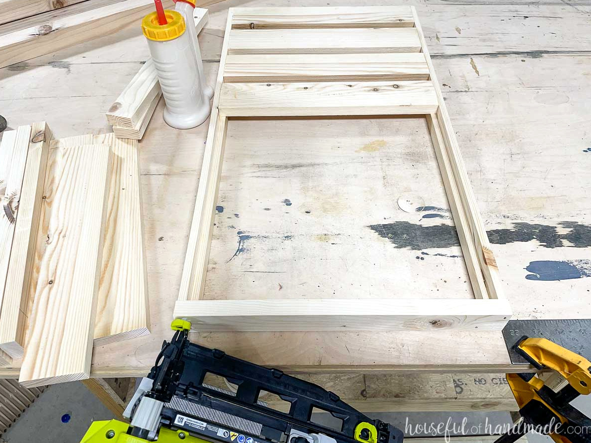 Fastening the back 1x2 to the rear of the tiered plant stand shelf. 