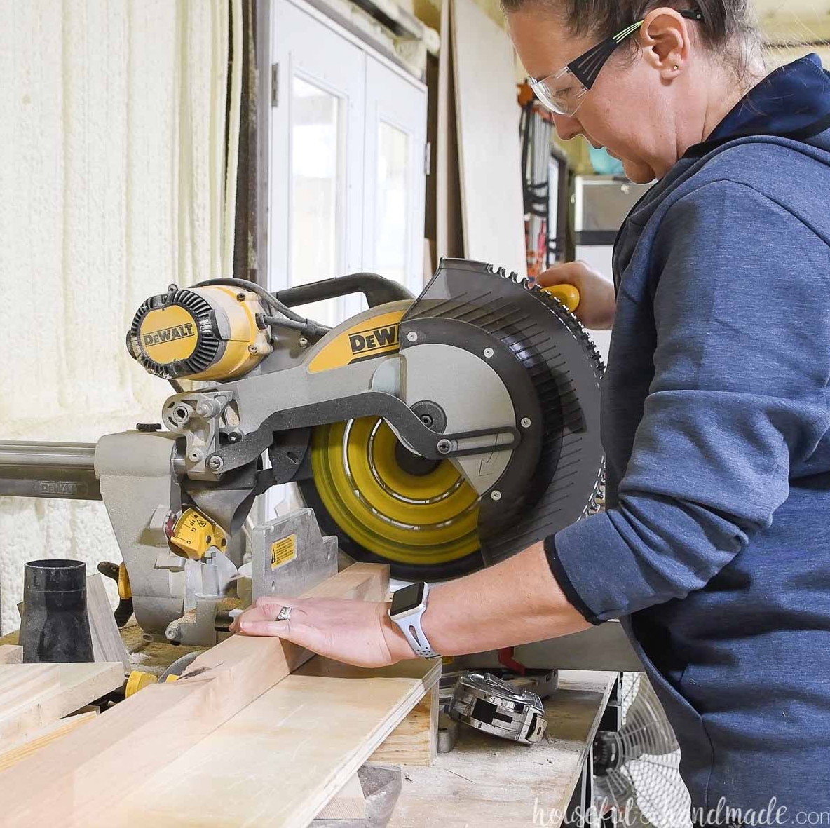 Woman cutting 2x2 boards with a sliding compound miter saw for the blanket ladder project.