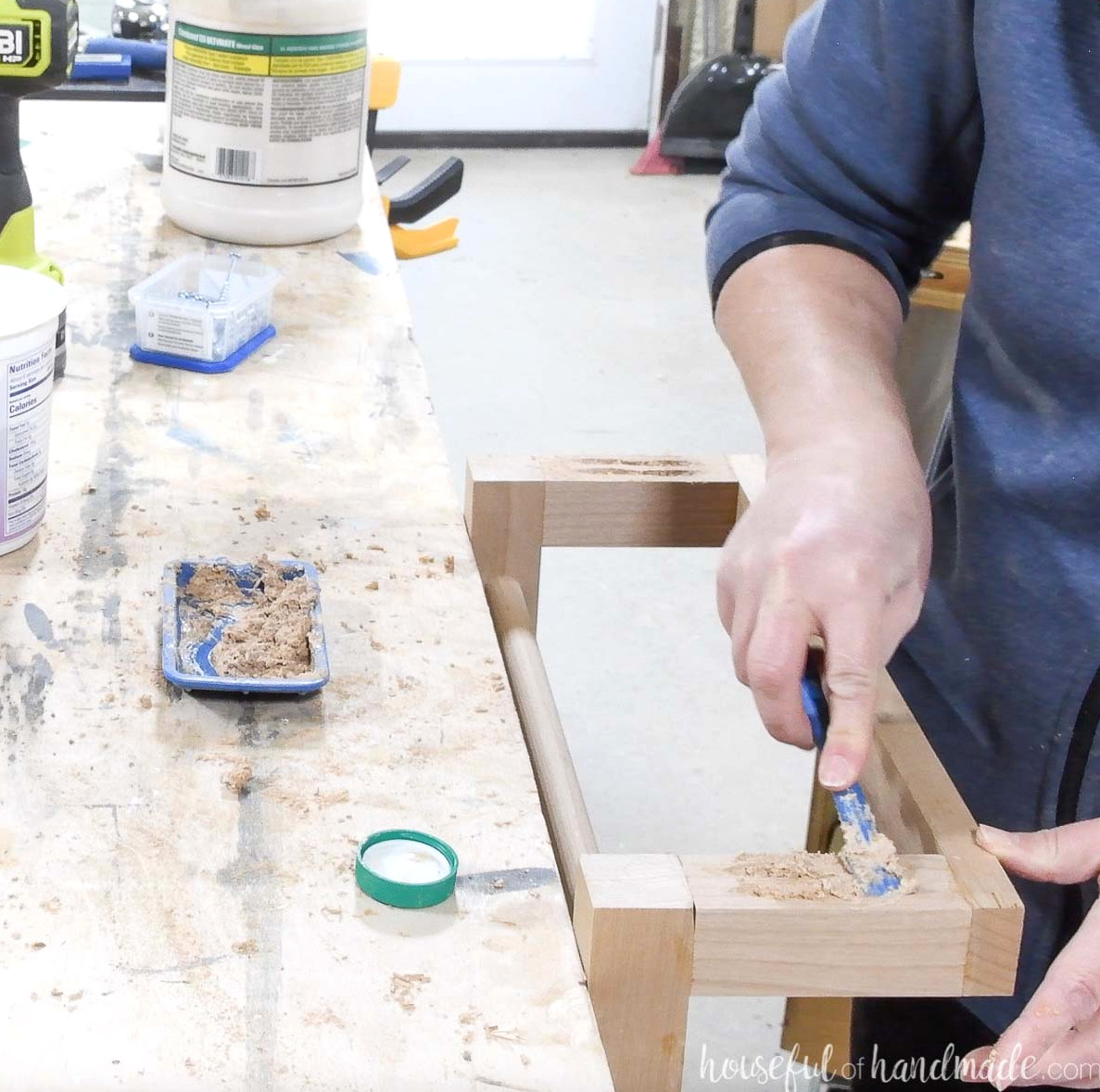 Covering pocket holes with a blend of wood glue and sawdust to conceal them on the blanket ladder.