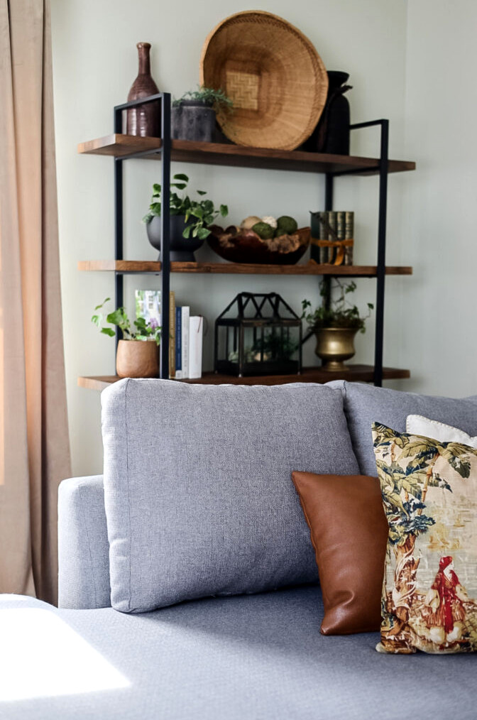 gray sectional with large bookcase behind it