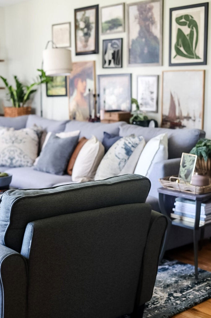 back view of a green chair looking into a living room with large gallery wall