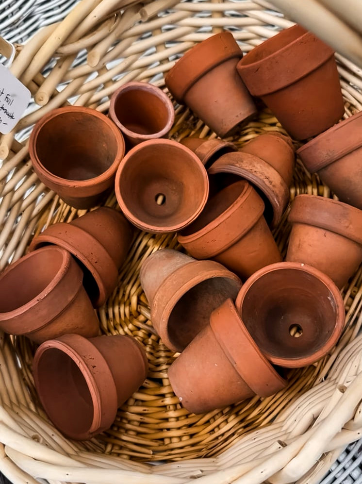 a basket of vintage terracotta pots