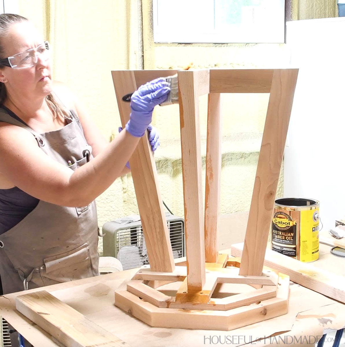 Applying outdoor sealer to the cedar birdbath.