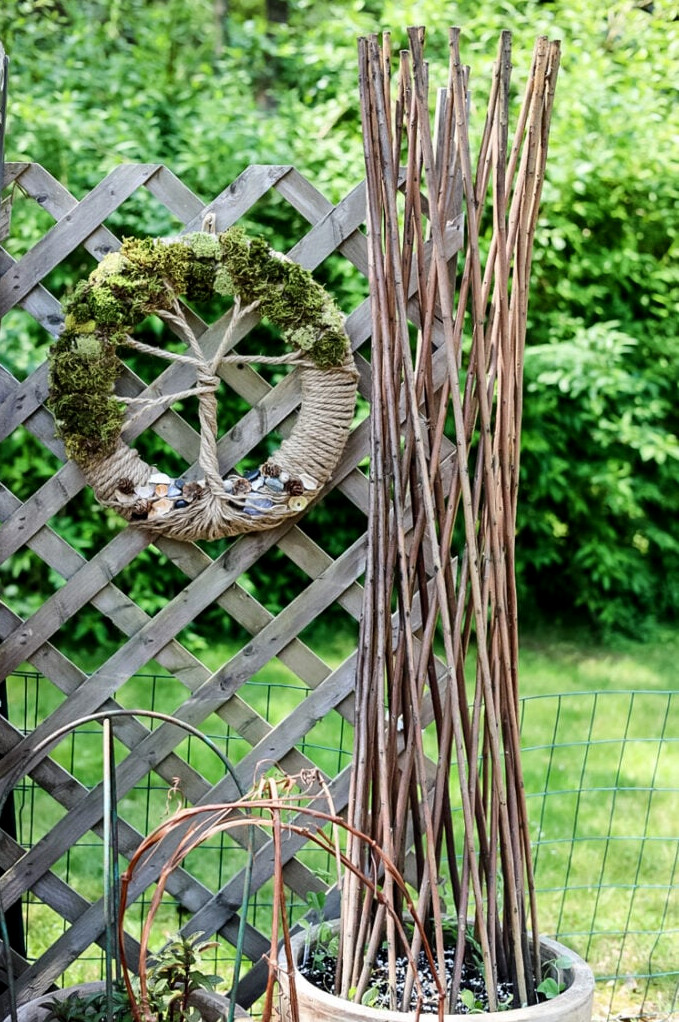 garden view with trellised planters and tree of life wreath