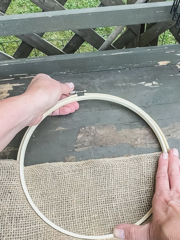 a woman's hands closing an embroidery hoop